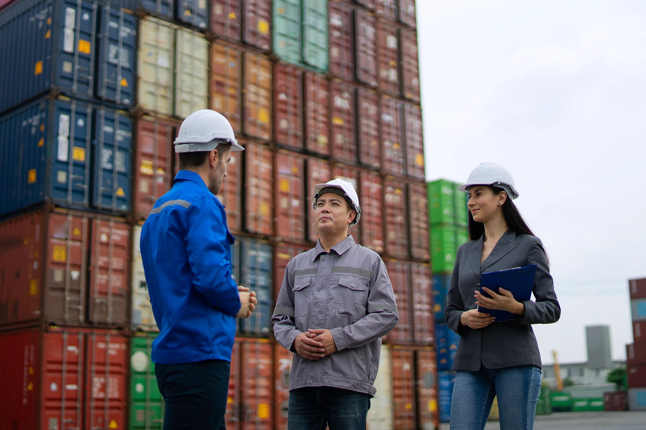 Port logistics staff working near containers during vessel operations