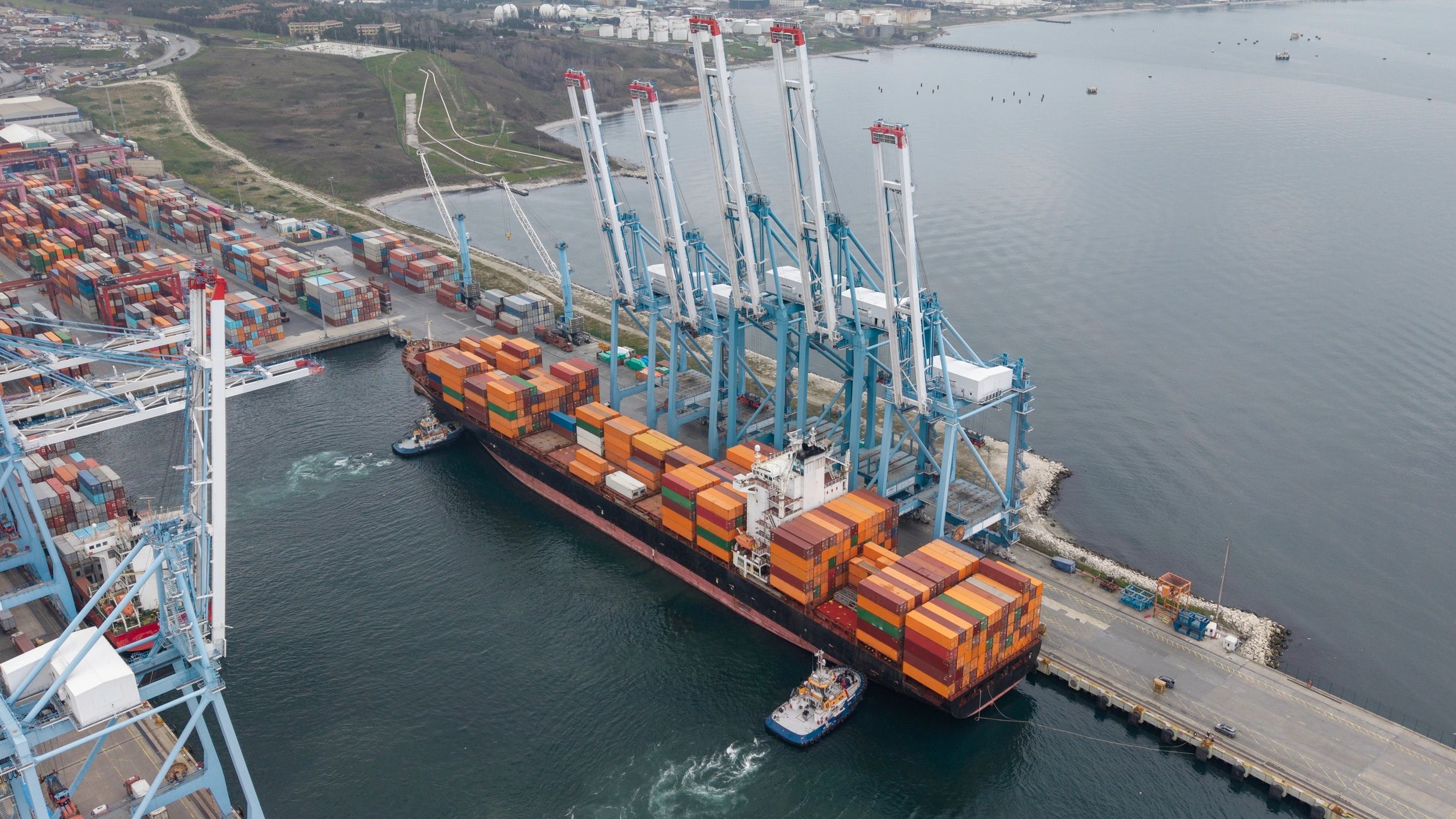 Container ship docking at an industrial port terminal